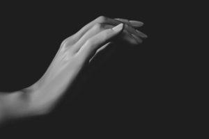 Hand reaching into darkness